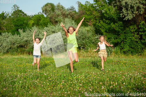 Image of Kids, children running on meadow in summer\'s sunlight