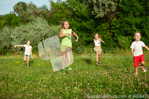 Image of Kids, children running on meadow in summer\'s sunlight