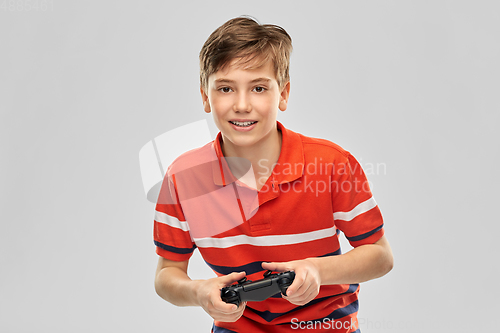 Image of smiling boy with gamepad playing video game