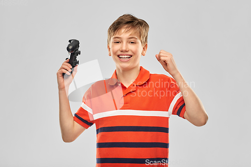 Image of smiling boy with gamepad playing video game