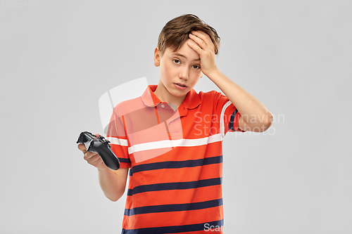 Image of unhappy boy with gamepad playing video game