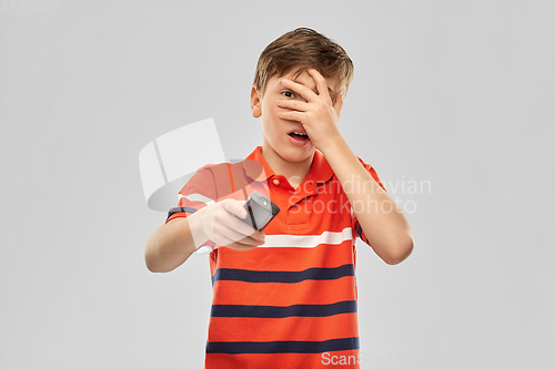 Image of scared boy with tv remote control