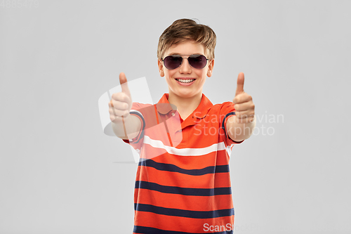 Image of smiling boy in sunglasses showing thumbs up