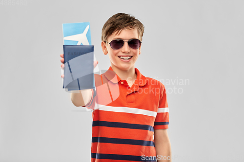 Image of happy boy in sunglasses with ticket and passport