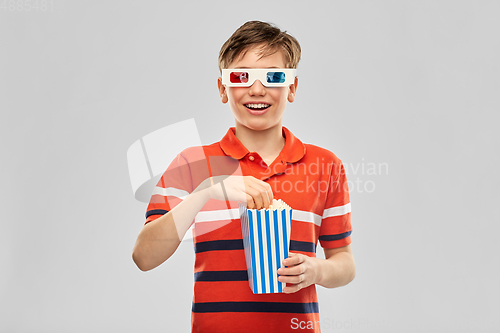 Image of smiling boy in 3d movie glasses eating popcorn