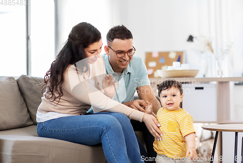Image of happy family with child sitting on sofa at home