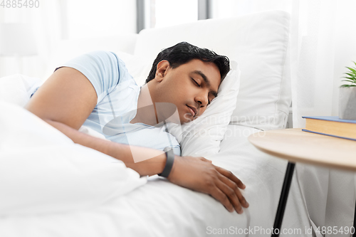 Image of indian man sleeping in bed at home