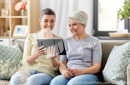 Image of daughter and senior mother with tablet pc at home