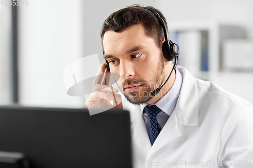 Image of male doctor with computer and headset at hospital