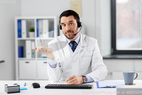 Image of male doctor in headset having video call at clinic