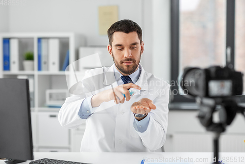 Image of doctor with hand sanitizer recording video blog