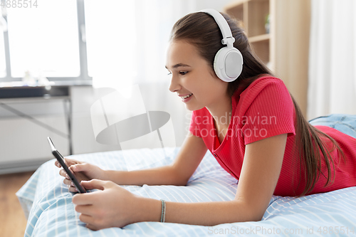 Image of girl in headphones listening to music on tablet pc