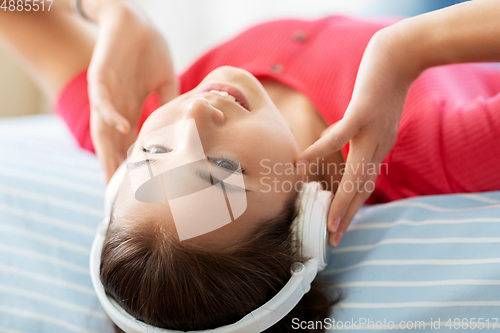 Image of girl in headphones listening to music at home