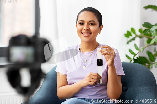 Image of female blogger with camera video blogging at home