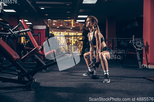 Image of Beautiful young sporty woman training, workout in gym