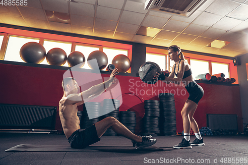 Image of Beautiful young sporty couple training, workout in gym together