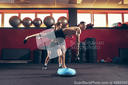 Image of Beautiful young sporty couple training, workout in gym together