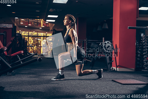 Image of Beautiful young sporty woman training, workout in gym