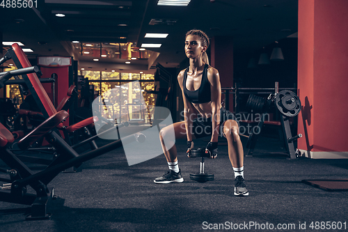 Image of Beautiful young sporty woman training, workout in gym