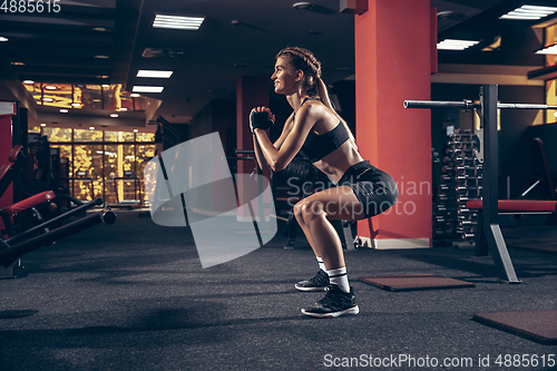 Image of Beautiful young sporty woman training, workout in gym