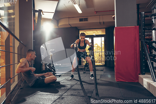 Image of Beautiful young sporty couple training, workout in gym together