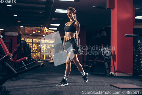 Image of Beautiful young sporty woman training, workout in gym