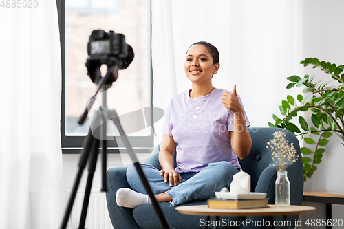 Image of female blogger with camera video blogging at home