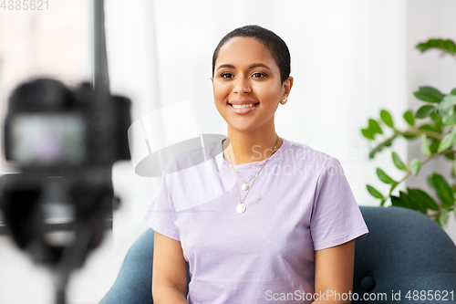 Image of female blogger with camera video blogging at home