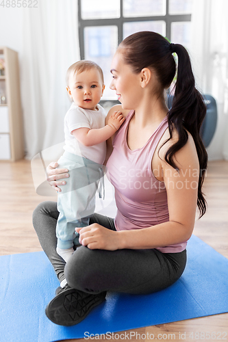 Image of happy mother with little baby at home