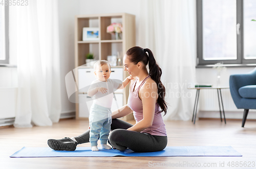 Image of happy mother with little baby at home