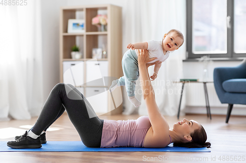 Image of happy mother with little baby exercising at home