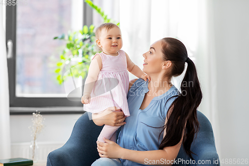 Image of happy mother with little baby daughter at home