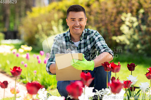 Image of man with clipboard and flowers at summer garden