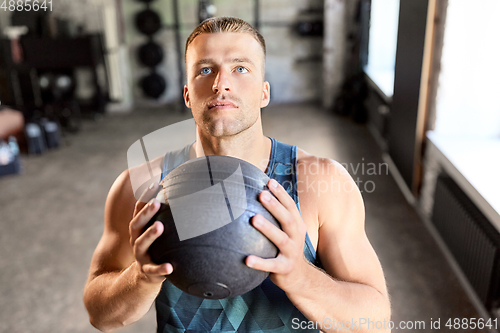 Image of young man with medicine ball in gym