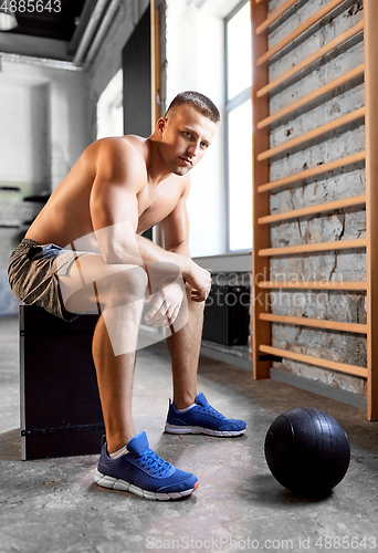 Image of young man with medicine ball in gym