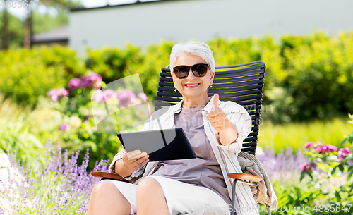 Image of happy senior woman with tablet pc at summer garden