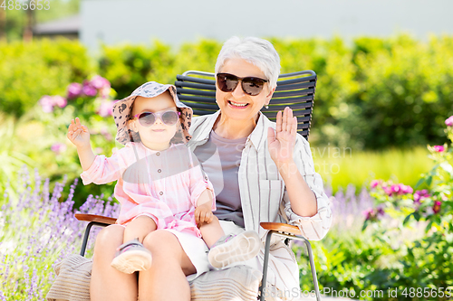 Image of happy grandmother and baby granddaughter at garden