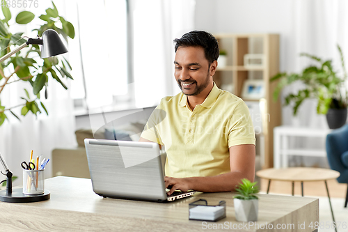 Image of indian man with laptop working at home office