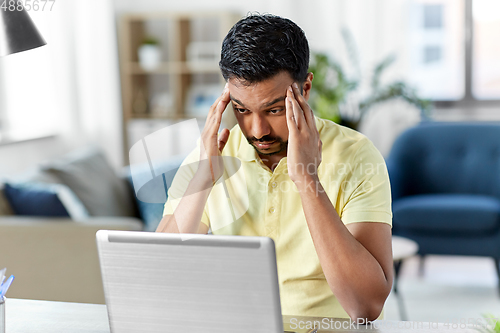 Image of indian man with laptop working at home office