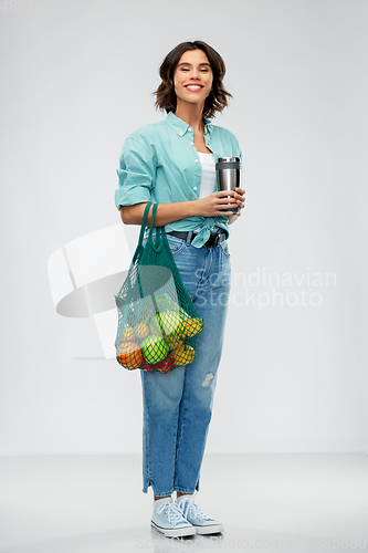 Image of happy smiling woman with food in reusable net bag