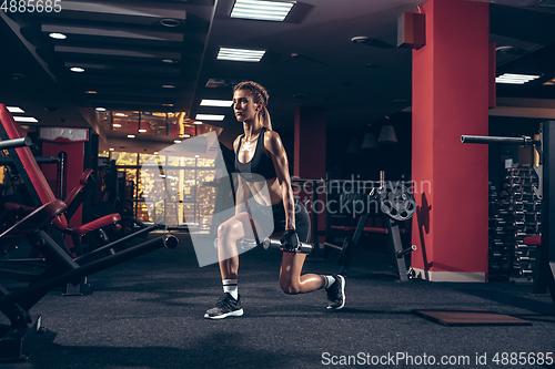 Image of Beautiful young sporty woman training, workout in gym