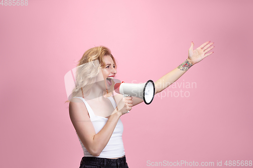 Image of Caucasian young woman\'s portrait isolated on pink studio background. Beautiful female model. Concept of human emotions, facial expression, sales, ad, youth culture.