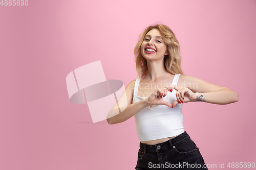 Image of Caucasian young woman\'s portrait isolated on pink studio background. Beautiful female model. Concept of human emotions, facial expression, sales, ad, youth culture.