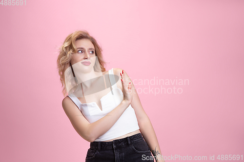 Image of Caucasian young woman\'s portrait isolated on pink studio background. Beautiful female model. Concept of human emotions, facial expression, sales, ad, youth culture.