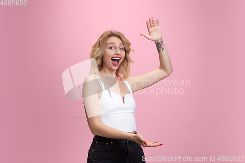 Image of Caucasian young woman\'s portrait isolated on pink studio background. Beautiful female model. Concept of human emotions, facial expression, sales, ad, youth culture.