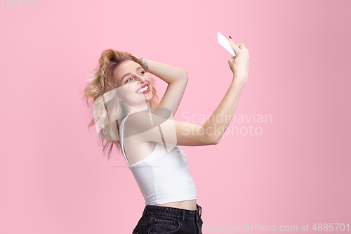 Image of Caucasian young woman\'s portrait isolated on pink studio background. Beautiful female model. Concept of human emotions, facial expression, sales, ad, youth culture.