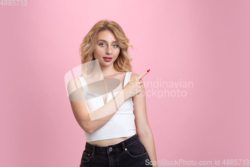 Image of Caucasian young woman\'s portrait isolated on pink studio background. Beautiful female model. Concept of human emotions, facial expression, sales, ad, youth culture.