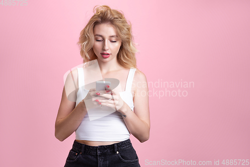 Image of Caucasian young woman\'s portrait isolated on pink studio background. Beautiful female model. Concept of human emotions, facial expression, sales, ad, youth culture.