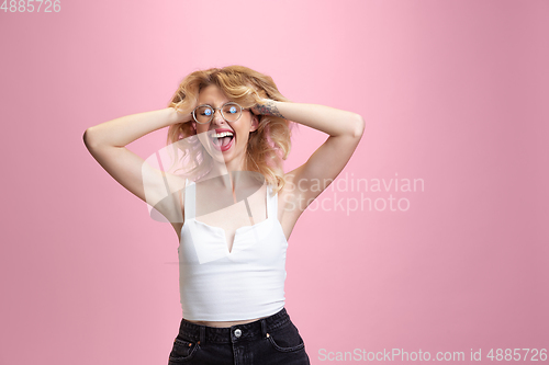 Image of Caucasian young woman\'s portrait isolated on pink studio background. Beautiful female model. Concept of human emotions, facial expression, sales, ad, youth culture.