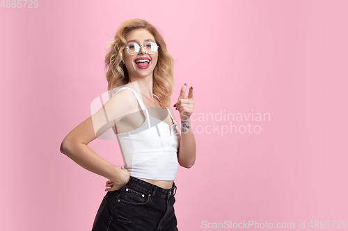 Image of Caucasian young woman\'s portrait isolated on pink studio background. Beautiful female model. Concept of human emotions, facial expression, sales, ad, youth culture.